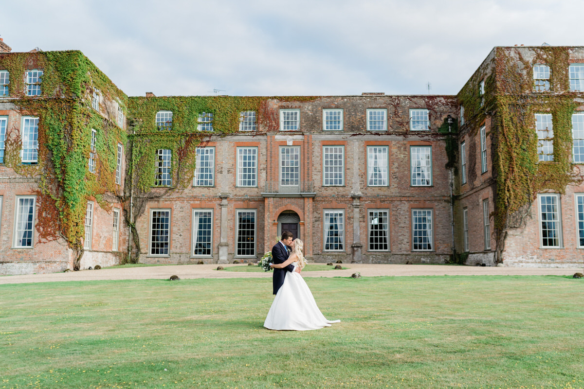 Couple kissing in front of Glemham Hall wedding venue in Suffolk.