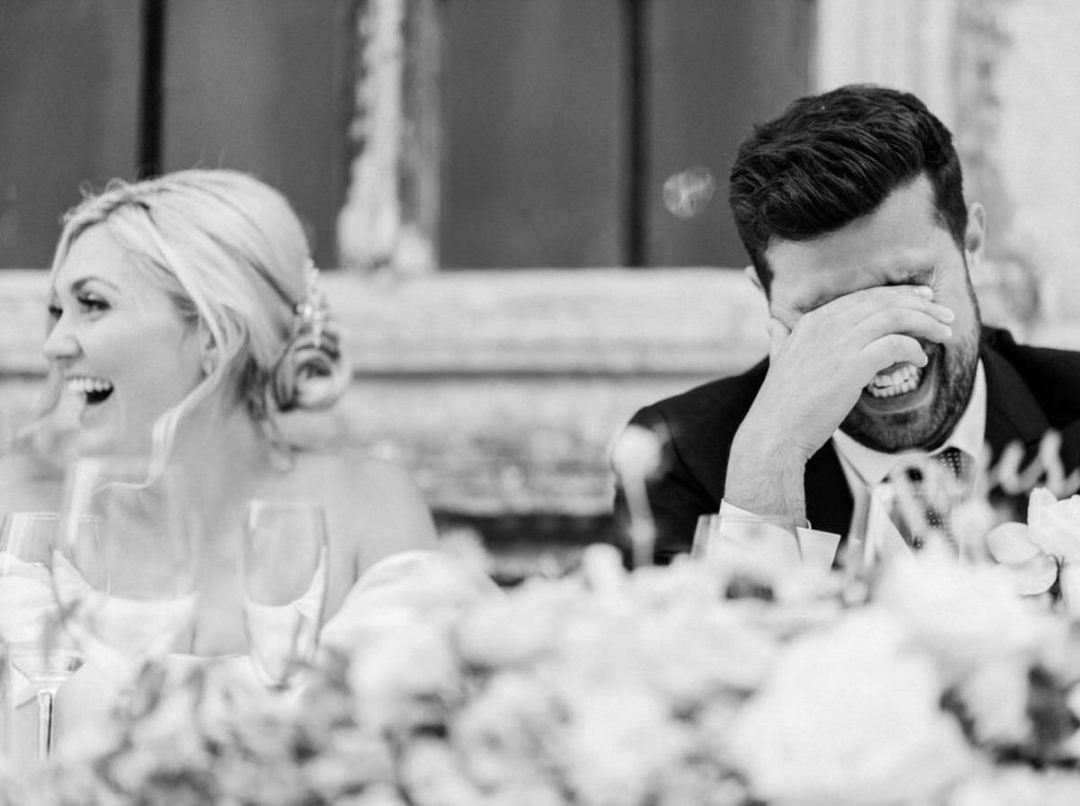 Groom laughing with head in his hands during the speeches at Bury St Edmunds wedding.