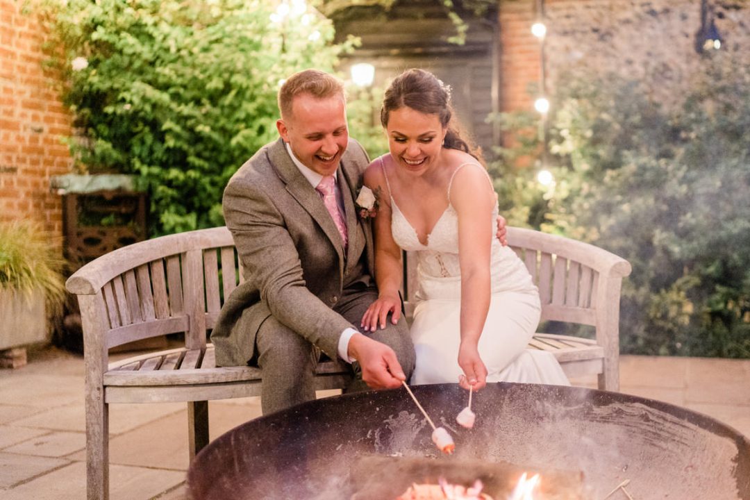 Bride and groom doing s'mores in The Granary Estates Courtyard