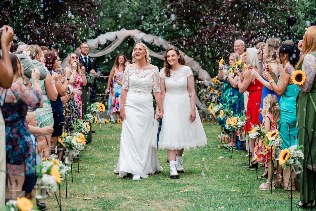 Bride and Bride bubble confetti line at Chalkney Water Meadows outside wedding venue in Colchester.
